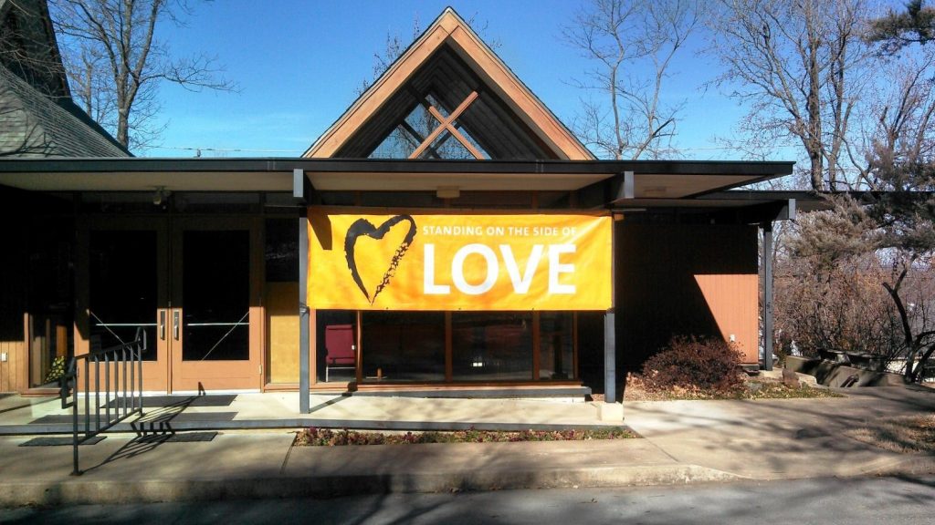 UUFF building with standing on the side of love banner