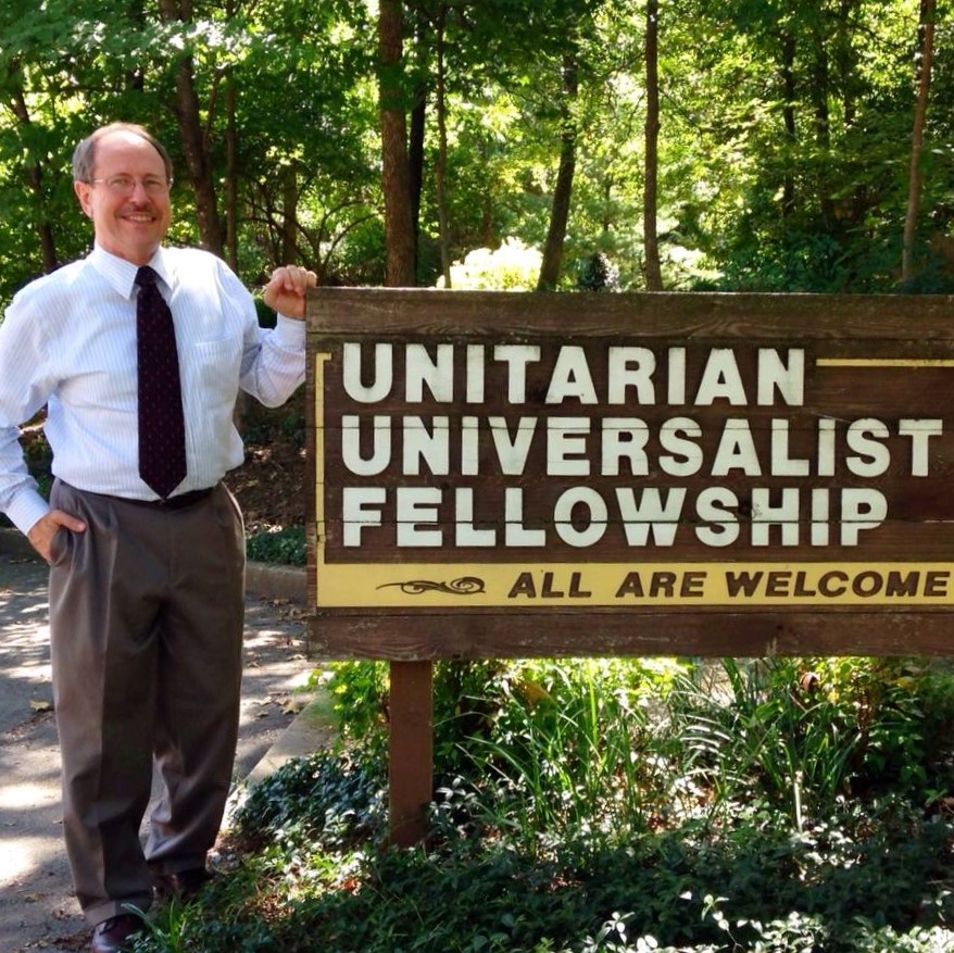 rev jim standing next to all are welcome sign